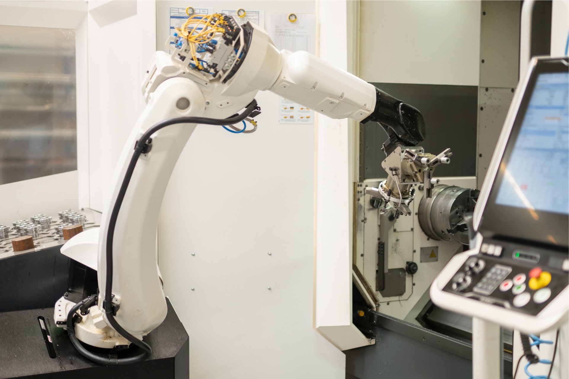 Roboterarm an einer CNC-Drehmaschine mit Bedienpult
