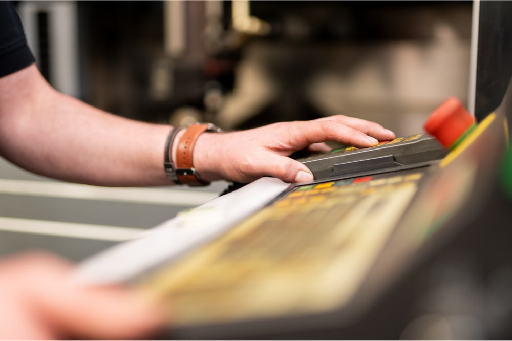 Hand an der Bedientafel einer CNC-Maschine